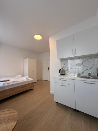 a kitchen with white cabinets and a bed in a room at Capital Stay Old Town in Sarajevo