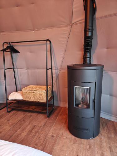a black stove in a room with a bed at Domein de Koekoeksvlooghe in Lo-Reninge