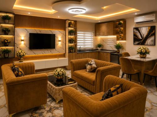 a living room with couches and a flat screen tv at Oak Haven Lodging & Suites in Sagamu