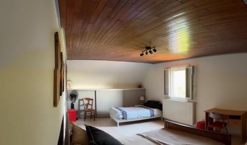 a bedroom with a bed and a wooden ceiling at Gîte Chez Clara in Rocamadour