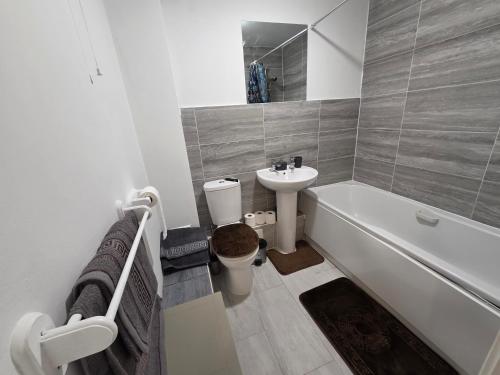 a bathroom with a sink and a toilet and a bath tub at 2bdr Ground Floor Flat in Edmonton free Parking and WiFi in Ponders End