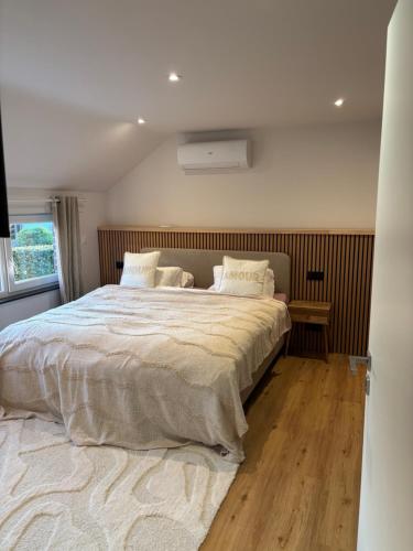 a bedroom with a large bed and a window at Maison des W in Jalhay