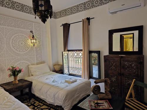 a bedroom with a bed and a dresser and a window at Hotel Atlas Gorge Dades in Boumalne Dades