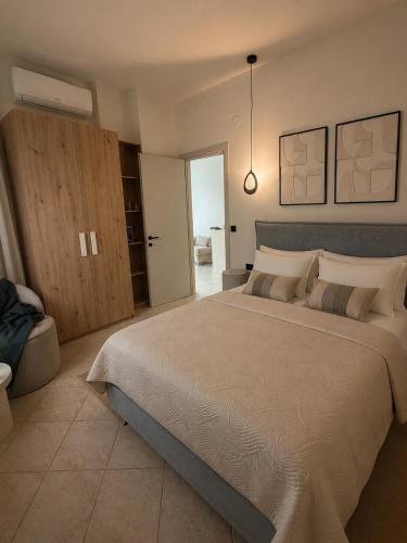 a bedroom with a large bed and a pendant light at Noema Park View in Xanthi