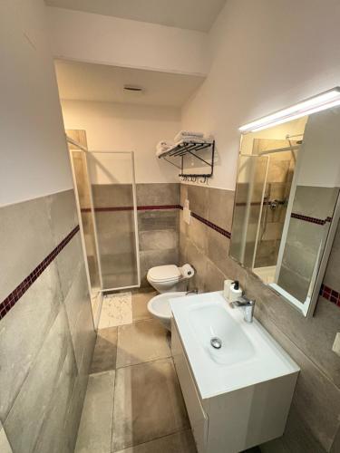 a bathroom with a white sink and a toilet at Bassa Marea in Nettuno
