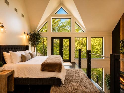 a bedroom with a bed and large windows at Fall Hideaway - VailsBluff - Romantic Escape in Broken Bow