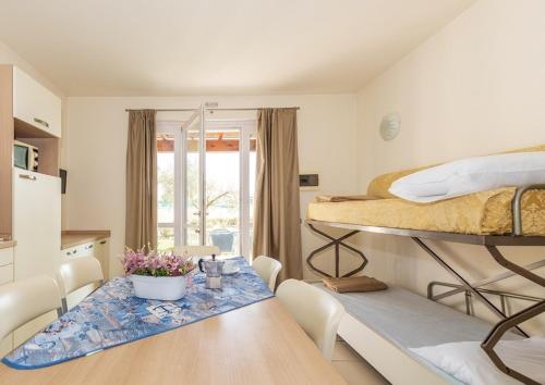 a room with a dining table and a bunk bed at Bungalow 2 2 in Sirmione