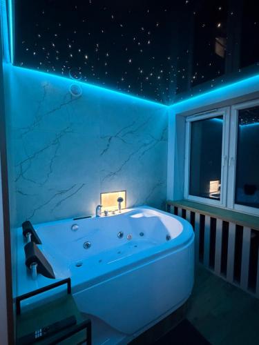 a bathroom with a white tub with a star ceiling at MAX Apartaments in Częstochowa