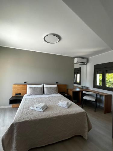 a bedroom with a bed with two towels on it at Tsonas Maisonette in Lygia