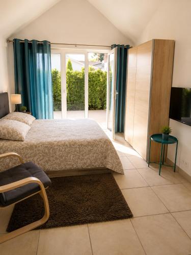 a bedroom with a bed and a sliding glass door at Studio Terrasse - Parking gratuit in Orléans