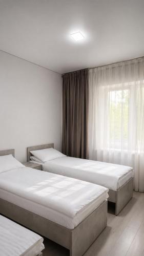 a room with three beds and a window at Золотые пески in Bosteri