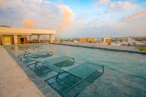 ein Schwimmbad mit zwei Liegestühlen auf einem Gebäude in der Unterkunft Zapadilly Tree Hotel in San Andrés