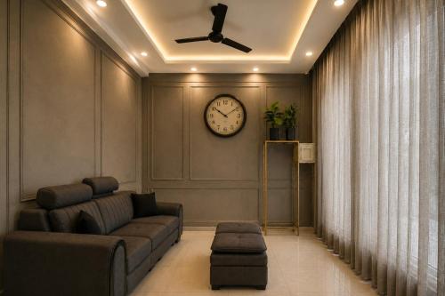 a living room with a couch and a clock on the wall at Hotel Galaxia Inn Near PEC College in Chandīgarh