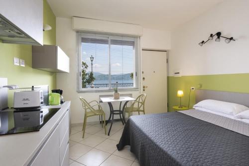 a bedroom with a bed and a kitchen with a table at Studio 2- lake view in Oggebbio