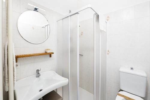a white bathroom with a sink and a shower at Studio 2- lake view in Oggebbio