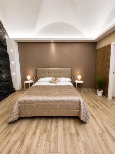 a bedroom with a large bed and two tables at Il Casale del 900 in Catania