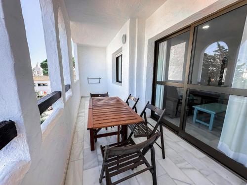 a wooden table and two chairs on a balcony at Vistahermosa Gestur Apartamentos in El Puerto de Santa María