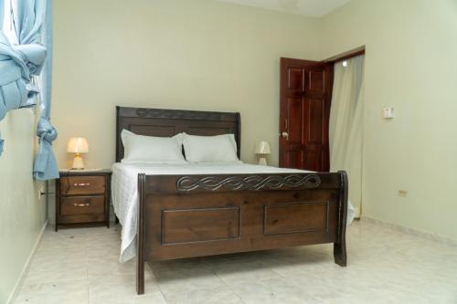 a bedroom with a bed with a wooden bed frame and a nightstand at bohiostay in Azua