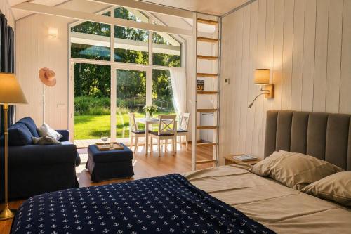 a bedroom with a bed and a living room with a window at Väänavilla Romantic Getaway in Vääna-Jõesuu