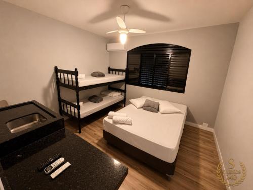 a small room with two beds and a bunk bed at Suítes Modernas com Ar-Condicionado e Estacionamento in Hortolândia