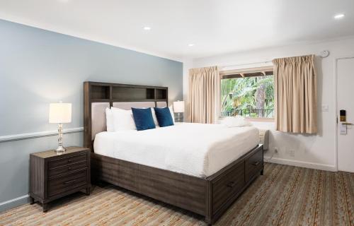 a bedroom with a large bed and a window at Inn by the Harbor in Santa Barbara
