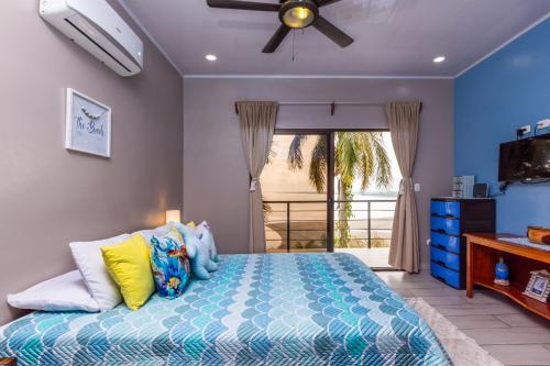 a bedroom with a bed and a ceiling fan at Mar y Sombra Villas in Quepos