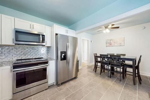 a kitchen with a stainless steel refrigerator and a table with chairs at East Nashville Discovery in Nashville