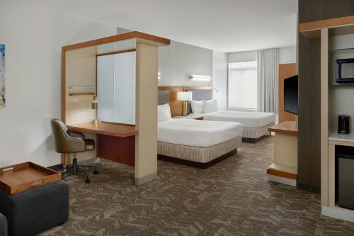 a hotel room with two beds and a desk at Springhill Suites by Marriott Detroit Metro Airport Romulus in Romulus