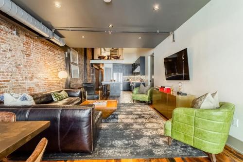 a living room with leather furniture and a brick wall at Tasteful Loft in Nashville