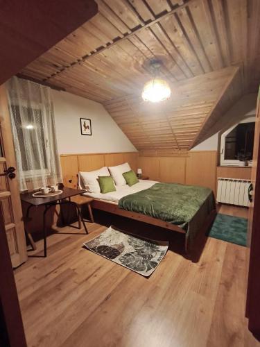 a bedroom with a bed and a table in a room at Willa Zwinka in Szczawnica