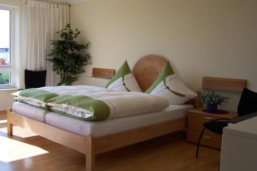 um quarto com uma cama com almofadas verdes e brancas em Marina 38-2 em Cuxhaven