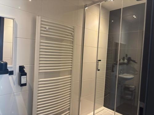 a glass shower in a bathroom with a sink at Hotel Zur Krone in Nordwalde