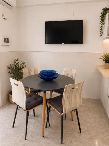 a dining room with a black table and chairs at Little Los Emilios in Torrevieja