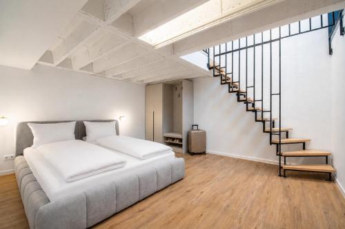 a bedroom with a large bed and a staircase at Altstadt City Loft in Würzburg
