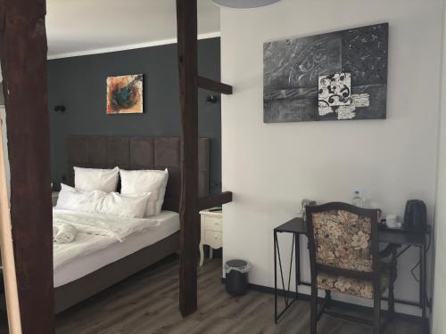 a bedroom with a bed and a desk and a chair at Hotel Zur Krone in Nordwalde
