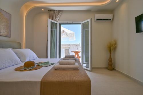 a bedroom with a bed with towels and a window at GuVer Luxury Suites in Agia Anna Naxos
