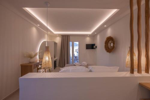 a white bedroom with two beds and a window at GuVer Luxury Suites in Agia Anna Naxos