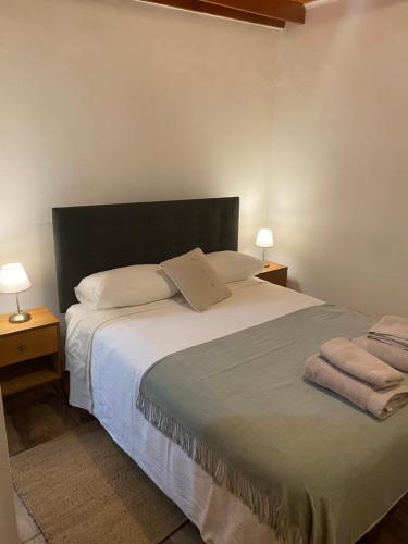 a bedroom with a large bed with two night stands at Casa Ckunna in San Pedro de Atacama