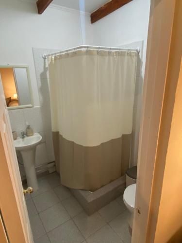 a bathroom with a shower curtain and a toilet at Casa Ckunna in San Pedro de Atacama