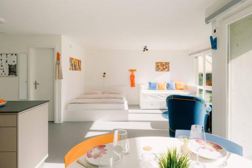a living room with a table and chairs and a bed at Apartment Baytrail in See- und Bergnähe, modern, mit Garten, 4 Gäste in Spiez