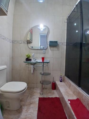 a bathroom with a toilet and a sink and a shower at Casa aconchegante in Manaus