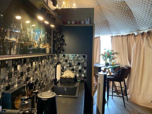 a kitchen with a sink and a counter with a table at Couple Baltic Coast Retreat in Apšuciems