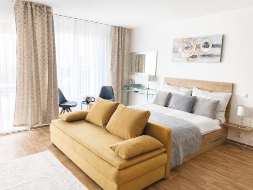 a bedroom with a bed and a couch at Apartmán Mia in Mikulov