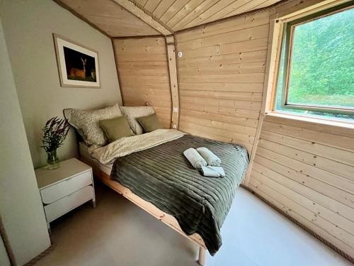 a small bed in a room with a window at Ostoja Szumilas in Kąsna Górna
