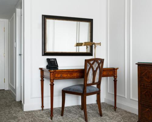 a desk with a phone and a mirror on a wall at Wedgewood Hotel & Spa - Relais & Chateaux in Vancouver