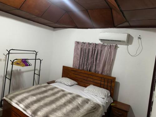 a bedroom with a bed and a air conditioner at Cosy appartement à Nongo in Conakry