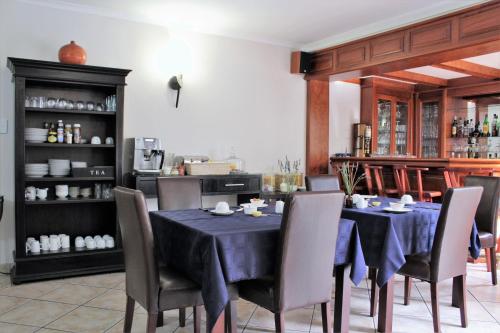 a dining room with a blue table and chairs at President Lodge in Edenvale