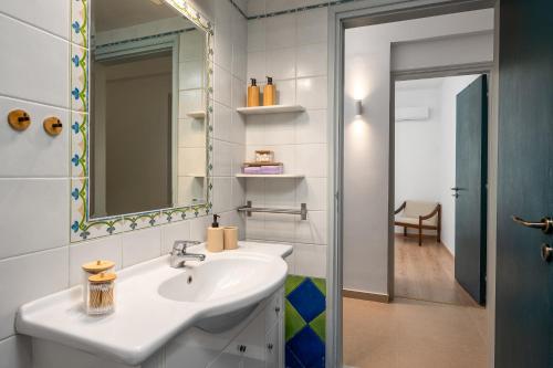 a bathroom with a sink and a mirror at Polytimi Summerhouse in Ialysos