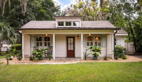 a small white house with plants in the yard at Pigeon Point Cottage with State Park Beach Pass in Beaufort
