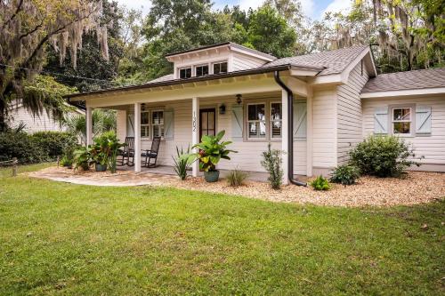 a small white house with a grass yard at Pigeon Point Cottage with State Park Beach Pass in Beaufort